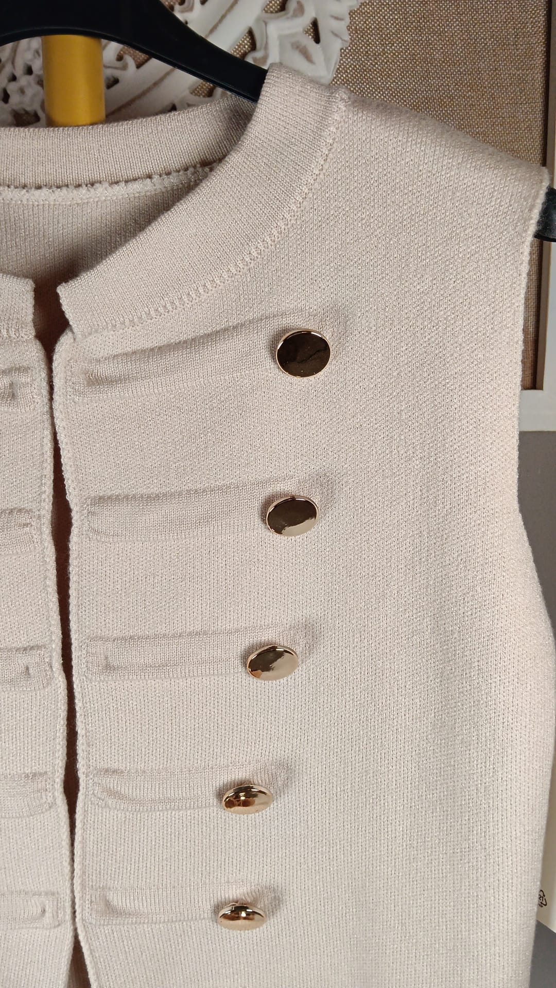Detalle del punto beige y los botones dorados del chaleco Napoleón