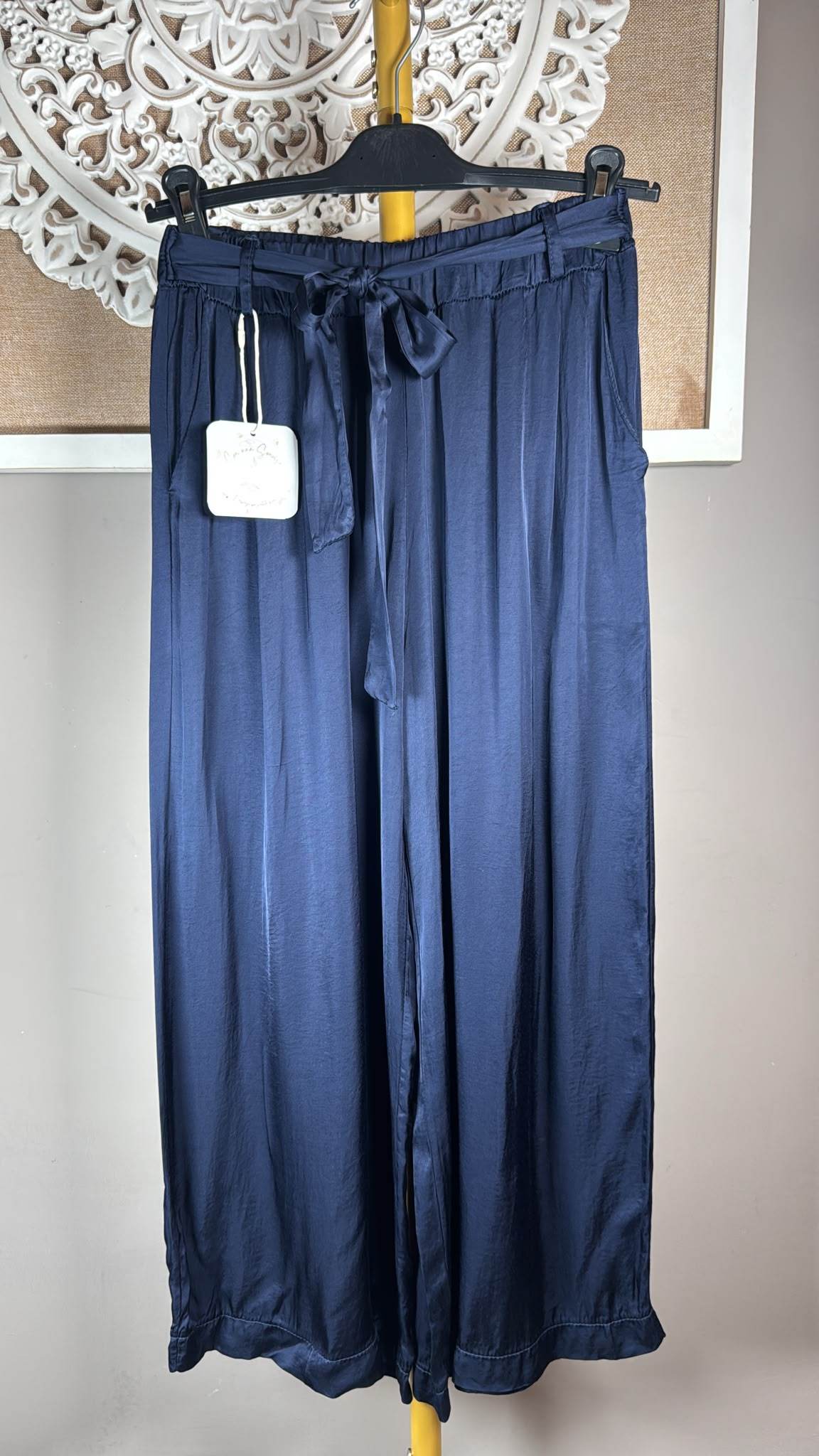 Detalle del tejido satinado y lazada del pantalón JOT marrón