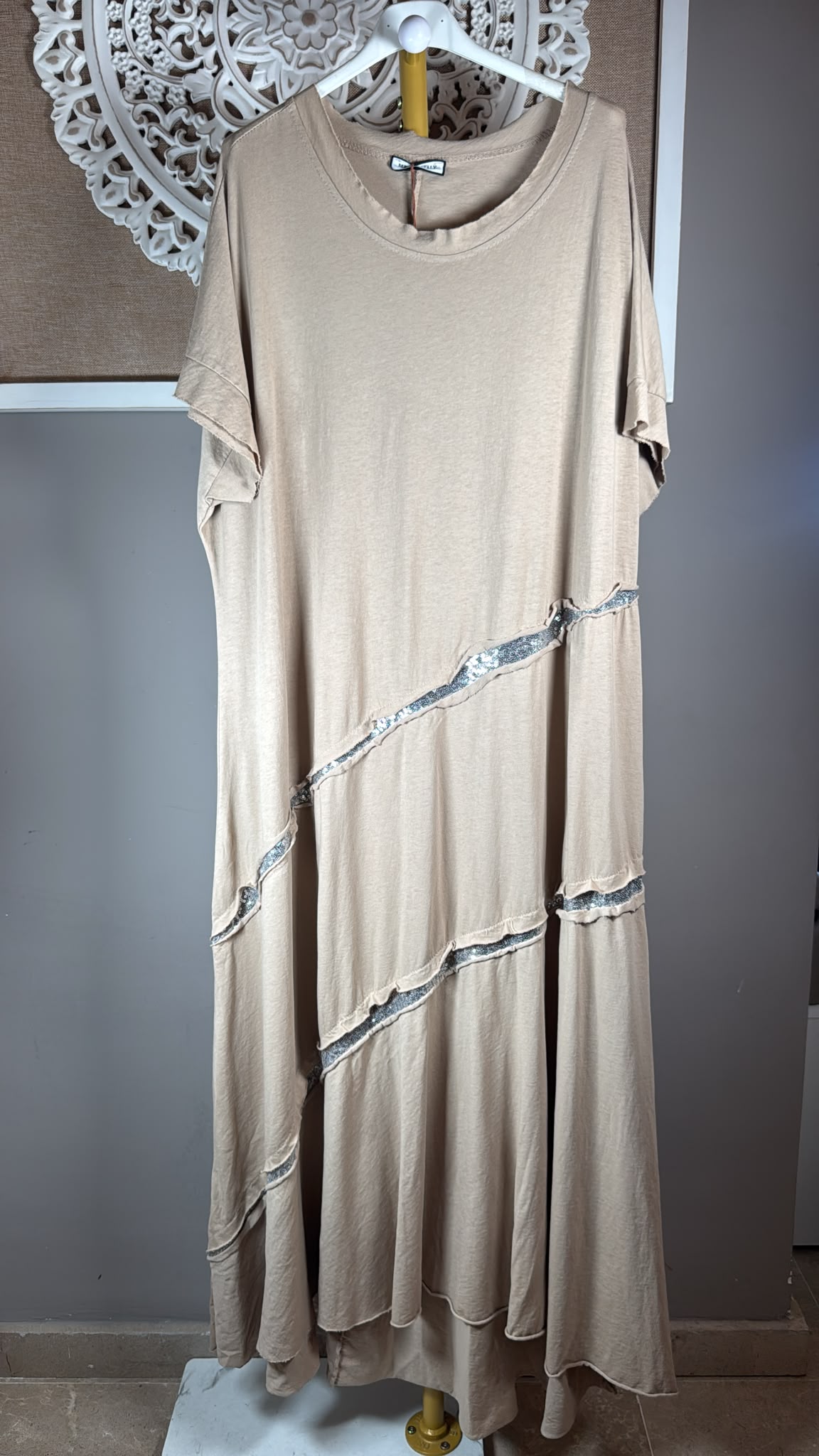 Detalle del tejido camel, lentejuelas plateadas y bajo cortado a láser del vestido Milano